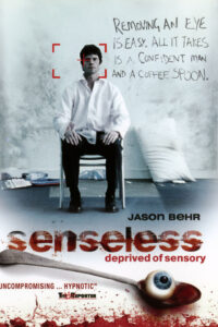 Poster for Senseless (2008), depicting a white man in a suit sitting on a chair in a dingy room, his face caught in red crosshairs, above an image of an eyeball on a bloody spoon.