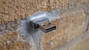 A USB drive mounted with cement into a brick wall.