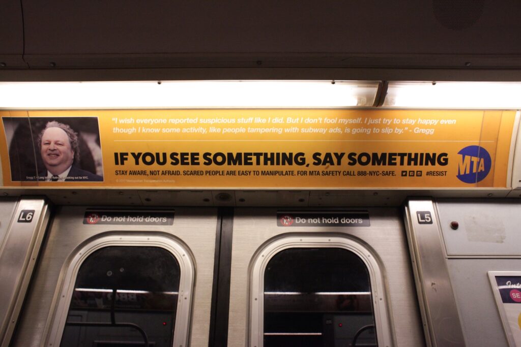 Photo of a culture jamming ad on the NYC Subway, depicting a fake MTA service announcement.