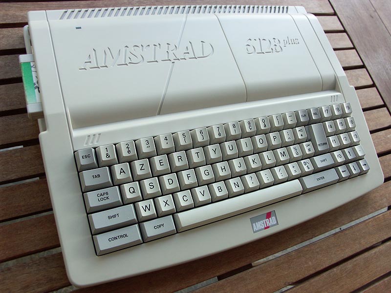 An Amstrad computer with an off white chassis and off white and gray computer keys.