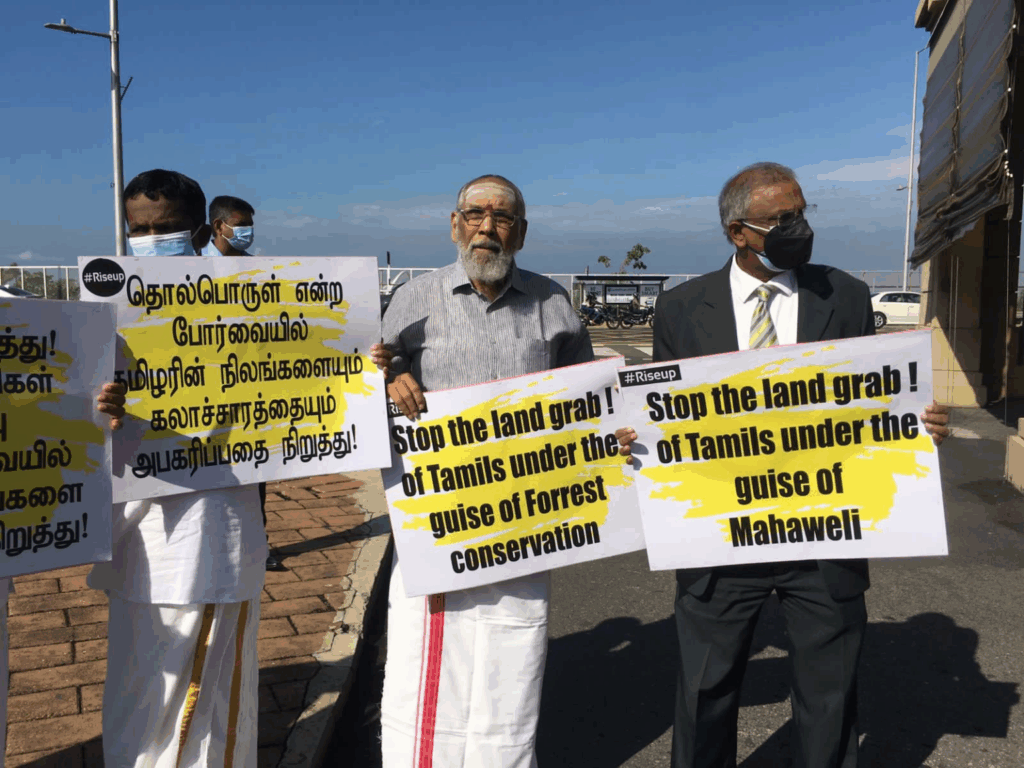 Stop Land Grabs in Eelam protest, depicting three Tamil men holding protest signs.